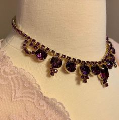 "A fabulous 1940s Mid Century statement necklace featuring pointed gold plated drops set with graduated clear purple rhinestones. The necklace is finished with a J clasp. Juliana style The necklace is in very good vintage condition. Length - 14.5 inches Largest Stone - 1\" Smallest Stone - 1/2\" Rhinestones - 1/8\" Date - Mid Century" Purple Vintage Jewelry For Party, Vintage Purple Jewelry With Rhinestones, Vintage Purple Rhinestone Jewelry, Purple Vintage Jewelry With Rhinestones, Purple Rhinestone Jewelry For Evening, Purple Rhinestone Evening Jewelry, Purple Jeweled Evening Jewelry, Statement Choker, Statement Choker Necklace