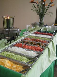 several trays of food are lined up on a table in front of the buffet