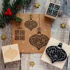 three rubber stamps with ornaments on them and christmas decorations in the background, including one ornament