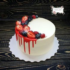 a white cake with berries and strawberries on top