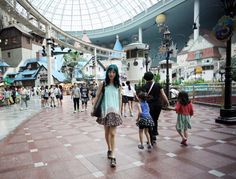 a woman and two children are walking through the mall