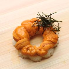 some kind of food that is on top of a wooden table and has been placed in the shape of a wreath