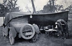 an old car is covered with a tarp and sits next to a cow in the yard