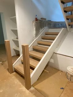 there is a wooden stair case next to the wall in this room that has been painted white