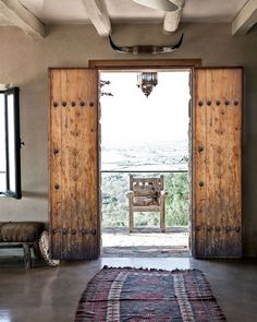 an open door leading to a balcony with wooden doors