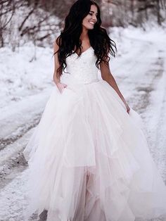 a woman standing in the snow wearing a wedding dress