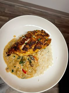 a white plate topped with meat and rice