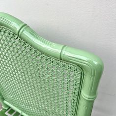 a green wicker bed frame against a white wall