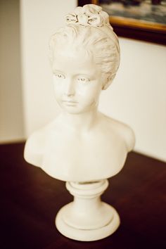 a white busturine sitting on top of a wooden table