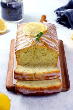 a loaf of lemon poppy seed bread on a cutting board next to sliced lemons