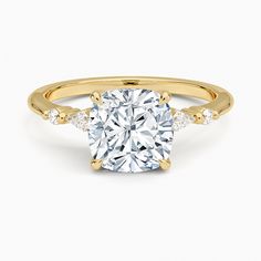 a yellow gold engagement ring with a cushion cut diamond