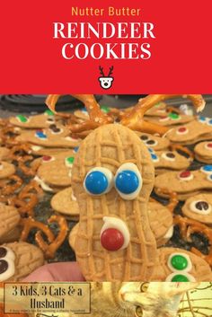 a close up of a person holding a cookie in front of a pile of cookies