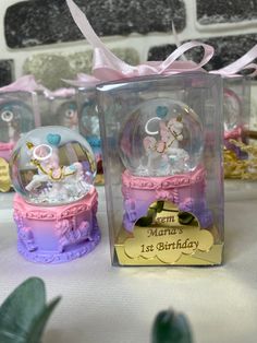 two snow globes sitting on top of a table next to each other in boxes