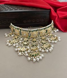 A glamorous bridal jewelry set for the contemporary bride of today! Beautiful meenakari kundan necklace set embellished with kundan stones and pearls detailing. The set includes a princess necklace, a tika and a pair of beautiful long earrings.  Details: Princess Necklace: Upper Choker Width-1.25 Inches Lower Choker Width-4 Inches Earrings Length-4.5 Inches Weight of Each Earring-21 gma Tika Length-7 Inches All products are manufactured using traditional skills from our rich heritage of crafts. Kundan Temple Jewelry Necklace For Wedding, Temple Style Kundan Necklace For Reception, Eid Reception Kundan Necklace, Silver Kundan Necklace With Zari Work For Ceremonial Occasions, Kundan Necklace With Meenakari For Wedding, Ceremonial Kundan Jewelry Set With Meenakari, Heavy Kundan Necklace For Eid Wedding, Wedding Kundan Temple Necklace With Cutdana, Bollywood Kundan Necklace With Zari Work For Reception