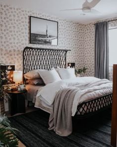 a bedroom with a bed, nightstands and pictures on the wall above it in black and white