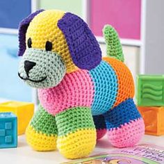 a crocheted dog sitting on top of a table next to blocks and toys