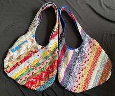 two colorful bags sitting on top of a black cloth covered bedding area next to each other