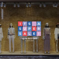 mannequins in front of a store window with the words it's a super sale up to 50 % off