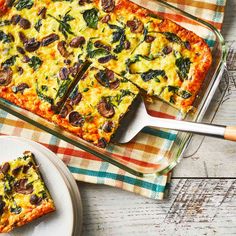 a casserole with cheese, mushrooms and spinach is on a plate next to a fork