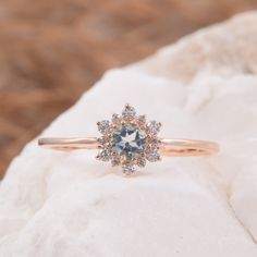 an engagement ring with a blue diamond surrounded by white and brown diamonds on top of a rock