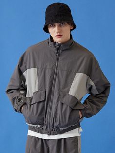 It is a trendy blouson fit jacket with high neck. The jacket has colorblock point and patched side pockets to make unique design. The elastic band cuffs and hem block wind and make comfy fit.- Two-way zipper- Colorblock point- Side pockets- Logo point Outerwear With Contrast Color For Spring Outdoor, Contrast Color Outerwear For Outdoor Spring Activities, Contrast Color Outerwear For Outdoor In Spring, Fall Outdoor Windbreaker With Zip Cuffs, Urban Long Sleeve Track Jacket With Contrast Color, Casual Winter Windbreaker With Zip Cuffs, Casual Winter Track Jacket With Elastic Cuffs, Winter Track Jacket With Elastic Cuffs And Long Sleeves, Gray Patchwork Outerwear For Streetwear