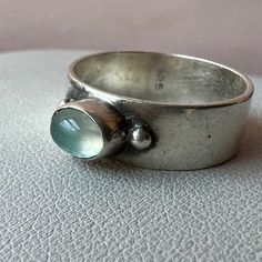 Beautiful Designer / Artisan Looking Wide Band Ring With A Pastel Aqua Blue Cabochon Glass Stone That Reminds Of An Aquamarine .Done In Solid 925 Sterling Silver ( Stamped And Tested ). Absolutely Gorgeous Color & Artisan Looking Ring! Cabochon Ring Design, Silversmith Rings, Chunky Silver Rings, Wide Band Ring, Cabochon Ring, Wide Band Rings, Aquamarine Blue, Wide Bands, Silver Jewellery