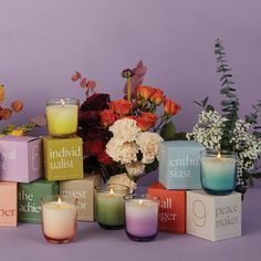 there are many candles and flowers in the vases next to each other on the table