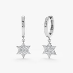 Jerus Meticulously handcrafted, these Star of David gold huggie earrings blend the timeless elegance of diamond hoops with a symbol of cultural significance. The natural diamonds add a touch of sparkle, making these earrings a meaningful and sophisticated accessory for any occasion. - Handmade- Solid Gold- Natural Diamonds- Total Diamond Carat Weight: 0.07 ctw- Diameters: Outer 11.5 mm, Inner 8.5 mm- Width: 1.6 mm- Charm: 6 mm * Sold as a pair * All pieces come beautifully boxed in suede pouches Round Star, Gold Huggie Earrings, Daily Wear Jewellery, Handmade Fine Jewelry, Diamond Star, Diamond Charm, Diamond Carat, Diamond Hoop Earrings, Huggie Earrings