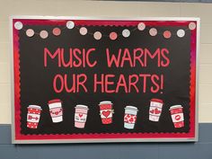 a sign that says music warms our hearts on the side of a school wall