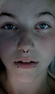 a woman with piercings on her nose looking at the camera