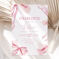 a pink and white birthday party card on a plate with palm leaves in the background