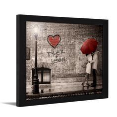 a couple kissing under an umbrella in front of a brick wall with the word love written on it