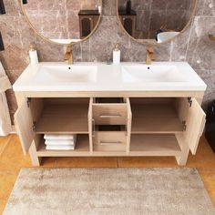 a bathroom with two sinks and mirrors on the wall next to a rug in front of it