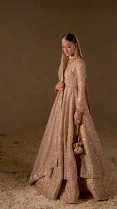 a woman in a wedding dress is standing on the sand with her handbag and purse