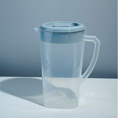 a plastic cup with a lid sitting on top of a white table next to a gray wall