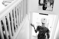 a woman is walking down the stairs with a frisbee on her head and arms