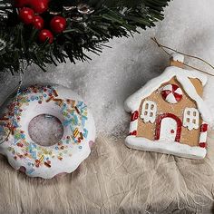 two ornaments are sitting next to each other on a fur covered surface with a christmas tree in the background