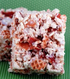 two pieces of food sitting on top of a green tablecloth covered in white and red toppings