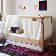 a child's bed with a white sheet over it