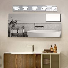 a bathroom with a sink, mirror and bathtub on the wall next to it