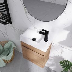 a white sink sitting under a mirror next to a towel rack and potted plant