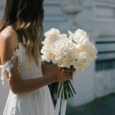 a woman holding a bouquet of white flowers