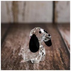 a glass dog figurine sitting on top of a wooden table next to a wall