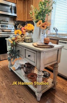 a kitchen island with flowers on it in the middle of a wooden flooring area