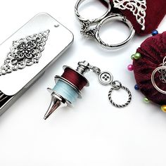 several different types of sewing accessories on a white surface with beads and thread spools