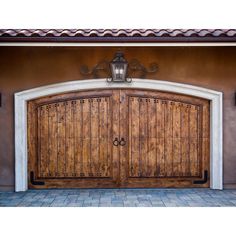 two wooden doors are open in front of a house