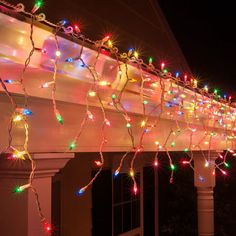 christmas lights are hanging on the side of a house