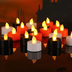 many lit candles sitting on top of a table