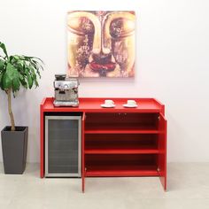 a red entertainment center next to a potted plant