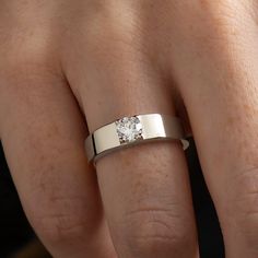 a close up of a person's hand with a wedding ring on their finger